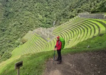 Young person overlooking the landscape with the terraces while doing a short inca trail 2 days
